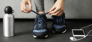 woman lacing up her shoes at the gym